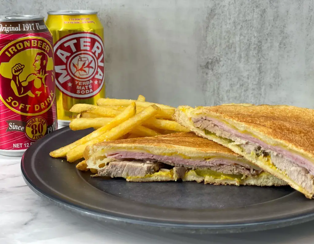 Cuban sandwich and french fries on a plate.