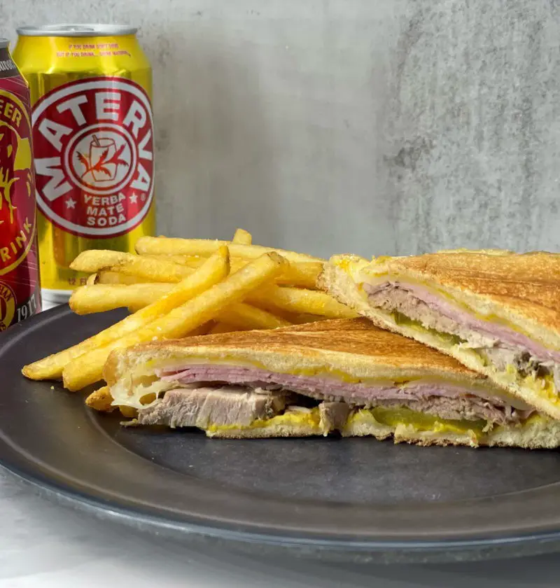 Cuban sandwich and french fries on a plate.