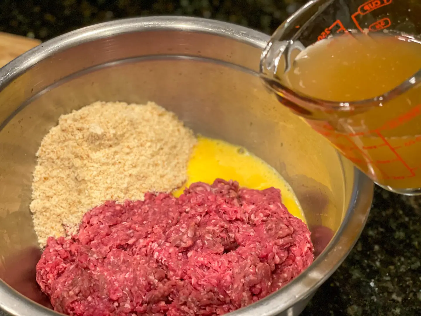 Photo of ground beef, egg, bread crumbs and beef broth for Cuban albondigas.
