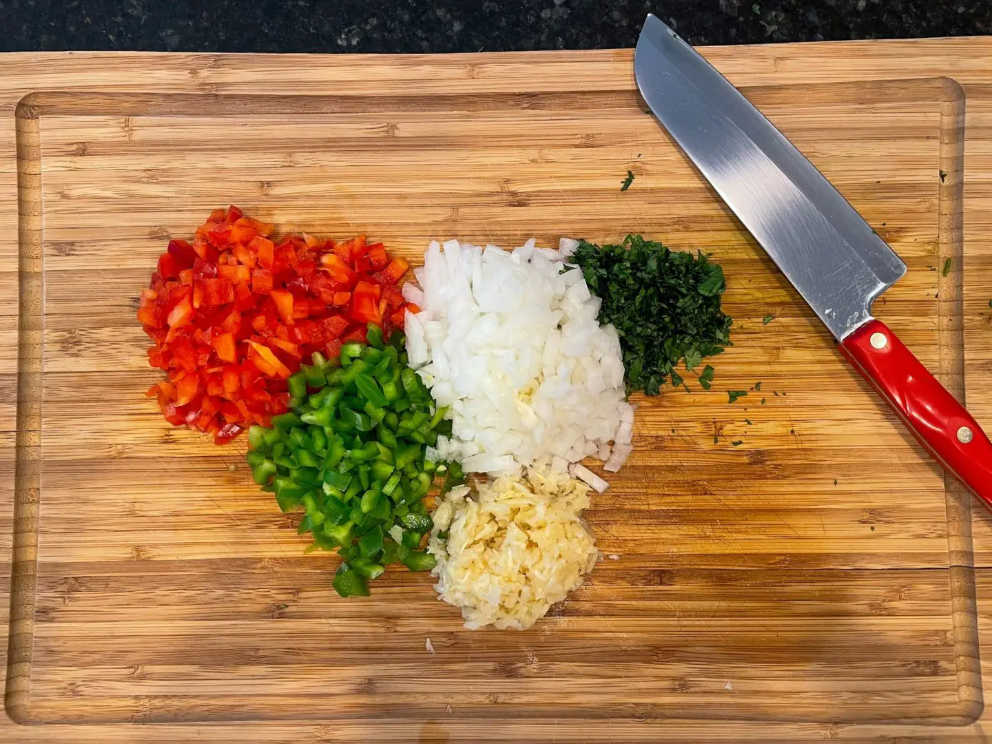 Photo of fresh red and green bell pepper, onion, garlic and fresh cilantro.