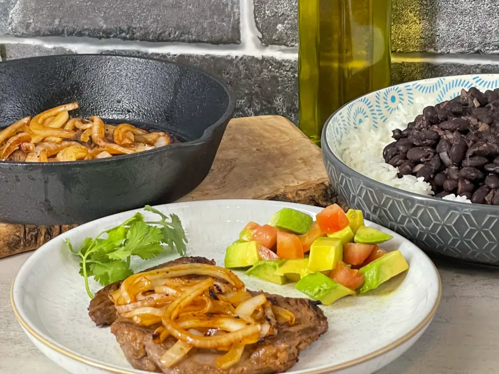 Bistec Encebollado on a dinner plate.