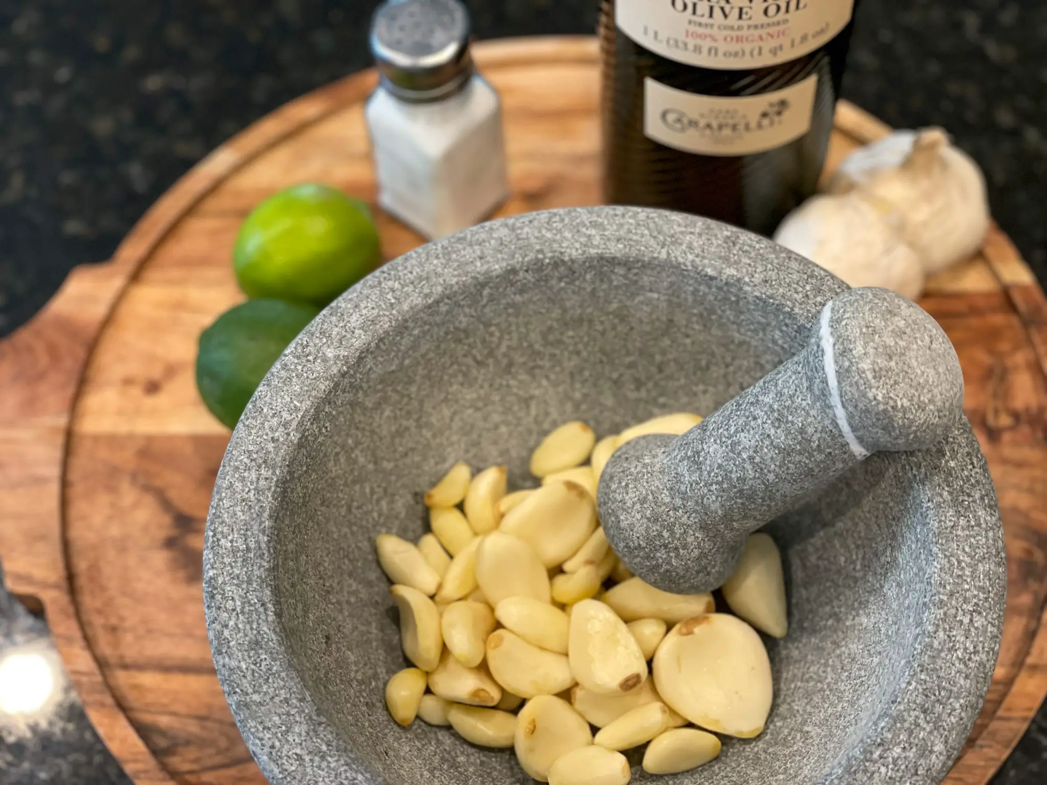 Using a mortar and pestle crush garlic for mojo criollo marinade.