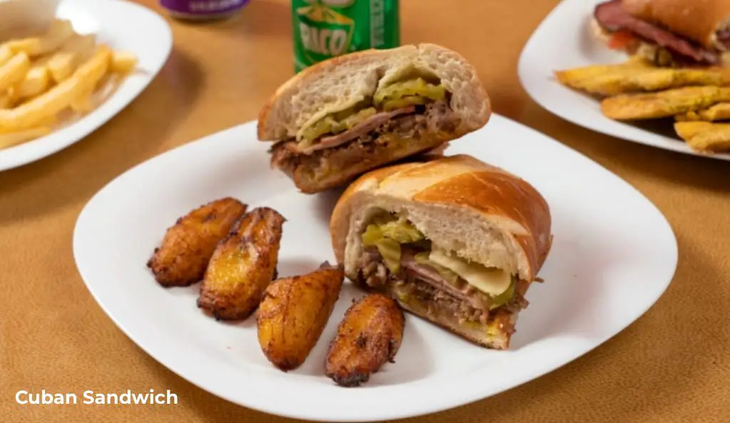 A Cuban sandwich cut in half served with maduros (fried sweet plantains).