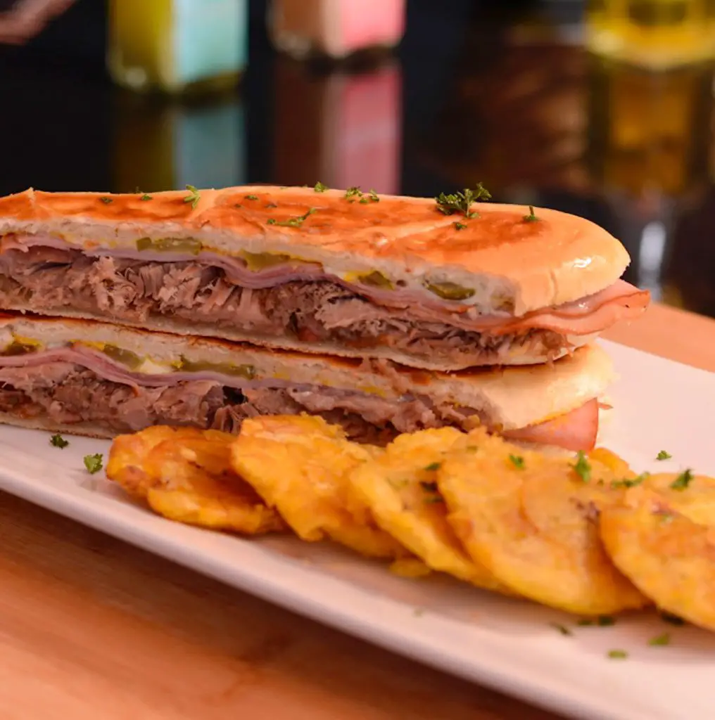 A Cuban sandwich served with tostones.