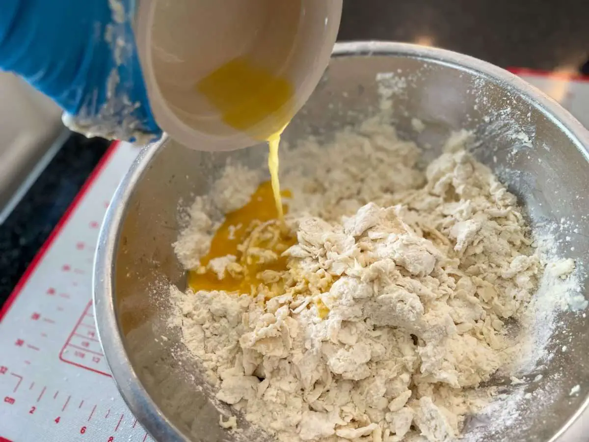 Adding orange juice to empanada dough.