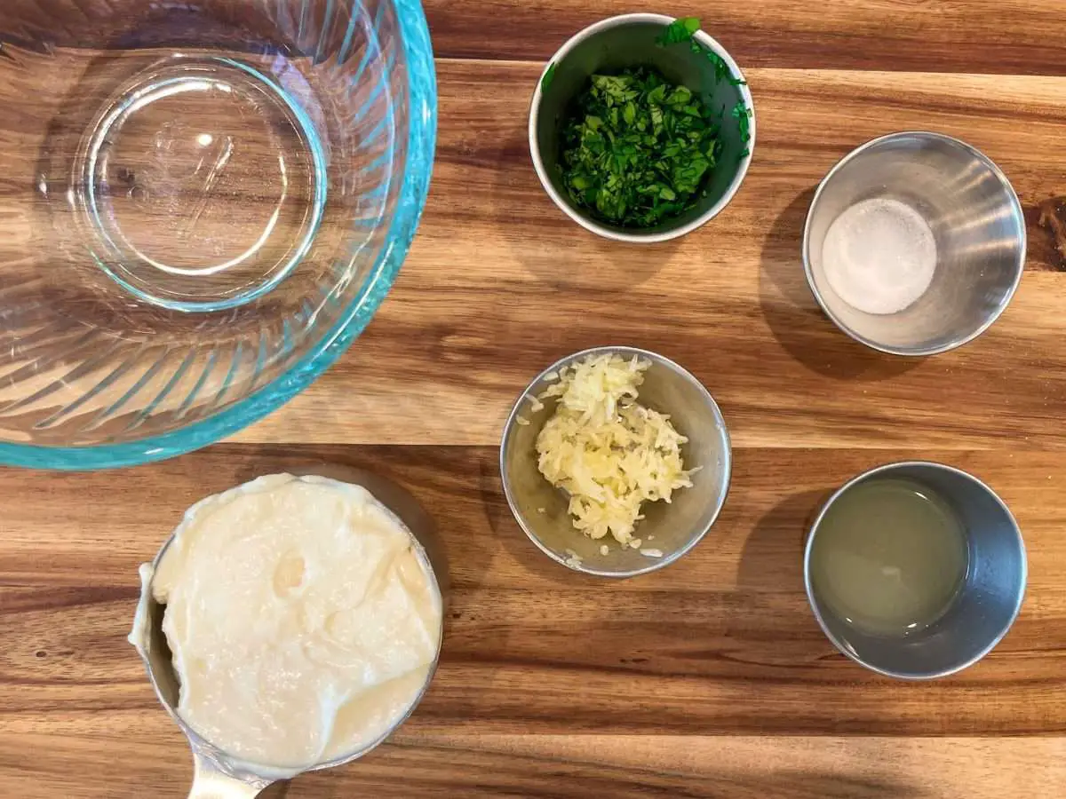Measuring the ingredients for cilantro aioli. 1 cup mayonnaise, minced garlic, lime juice and salt.