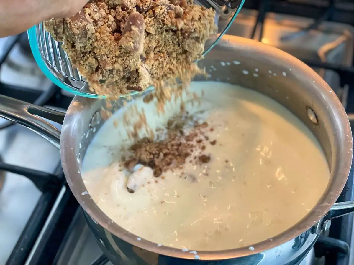 Adding piloncillo to simmering milk, vanilla paste and baking soda.