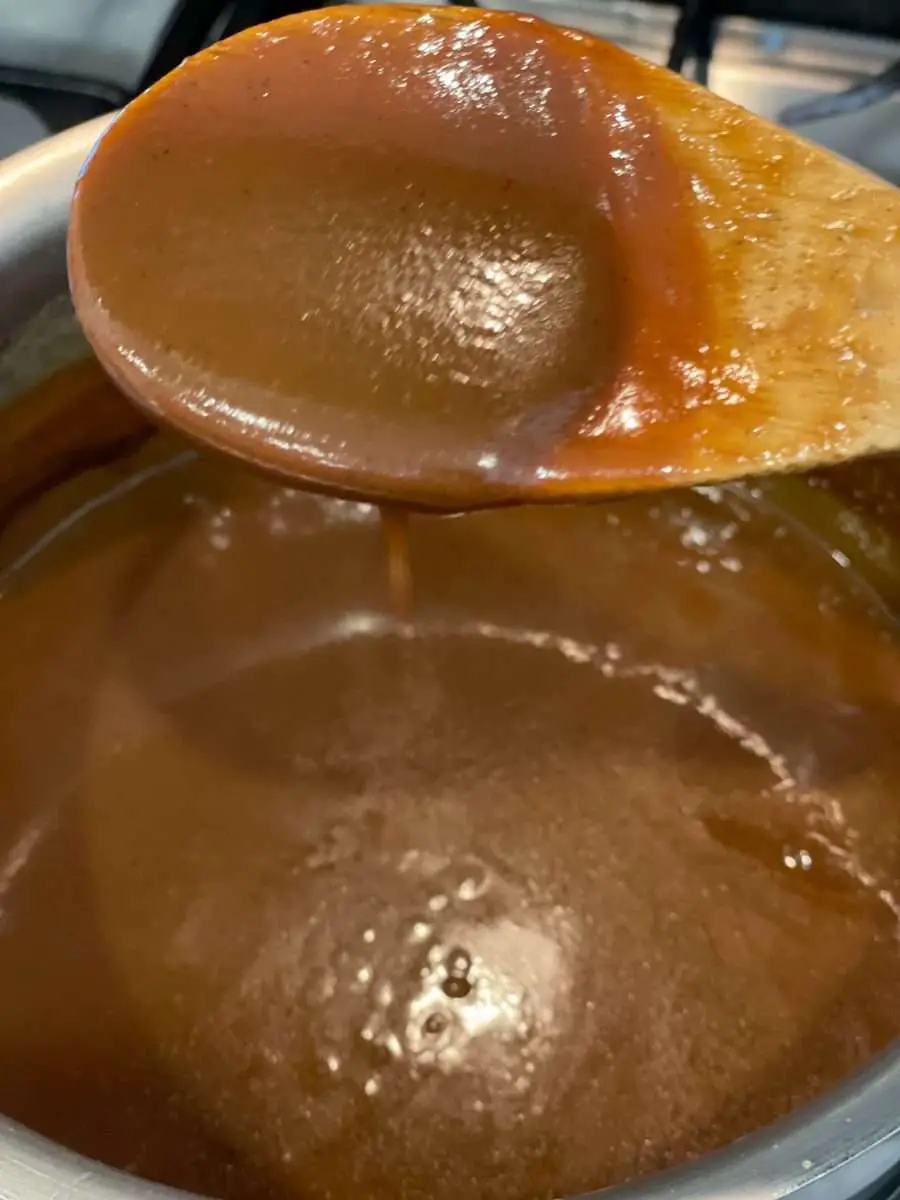 Dulce de leche staying on a wooden spoon showing that has finished cooking.