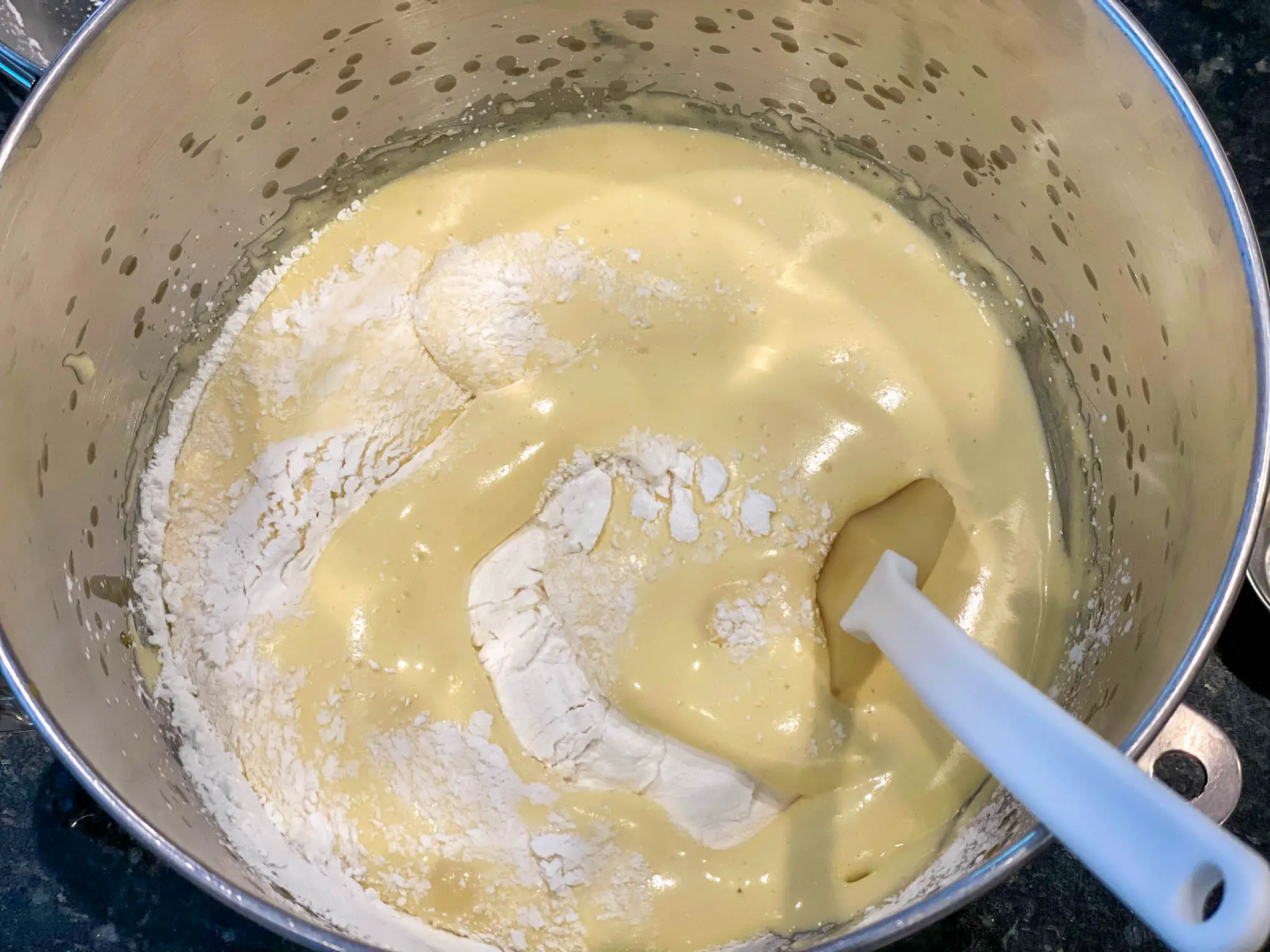 Folding dry ingredients into egg and sugar mixture.