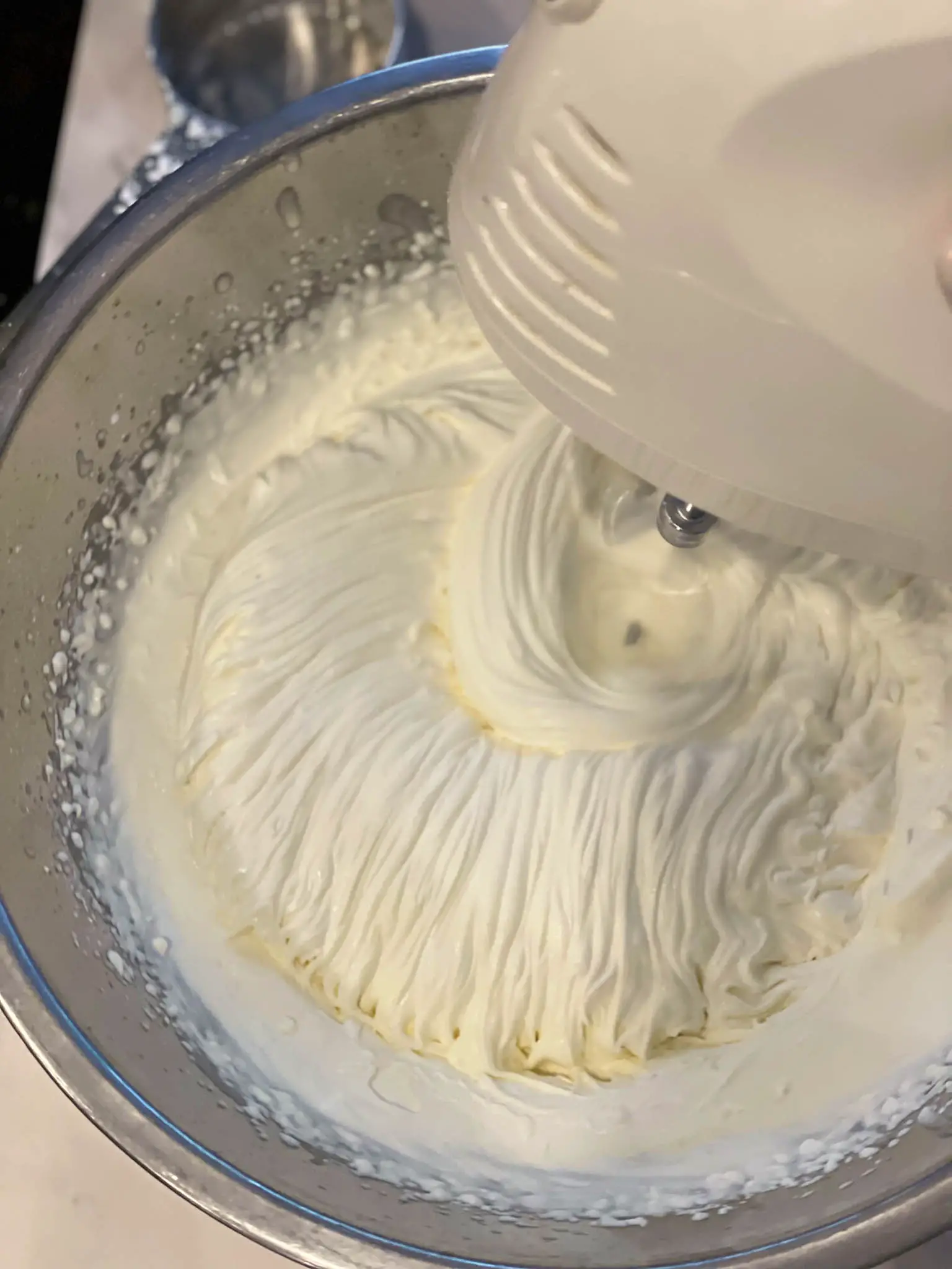 Stiff peaks forming while whipping the cream, sugar and vanilla.